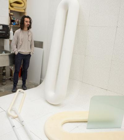 person in studio with large sculptural work