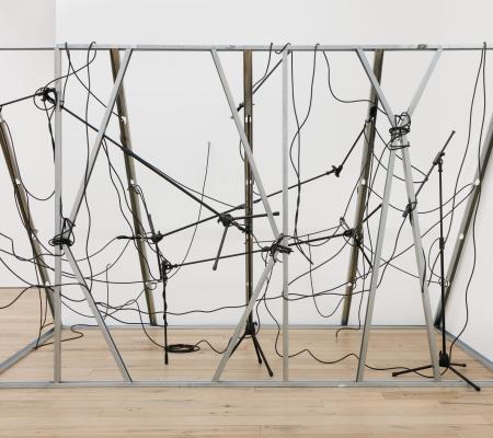 Installation image of Nikita Gale work Interceptor featuring Mic stands cables metal studs