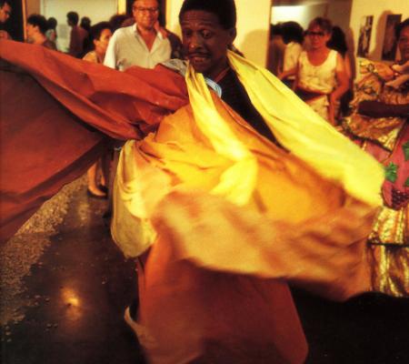 Man dancing in traditional garb in art exhibit