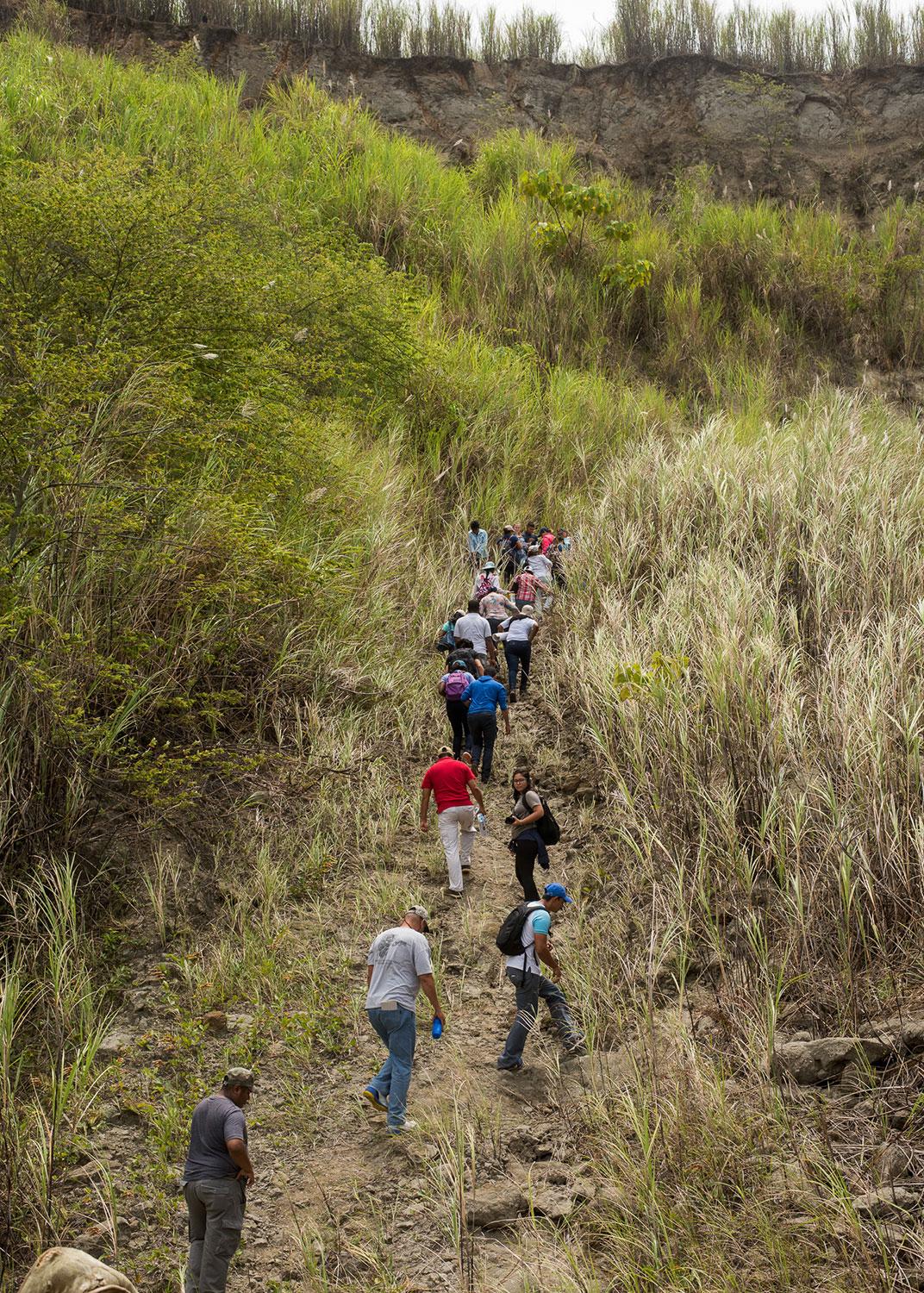 group of people hiking through field