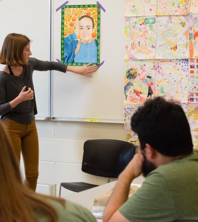 student presenting artwork in class