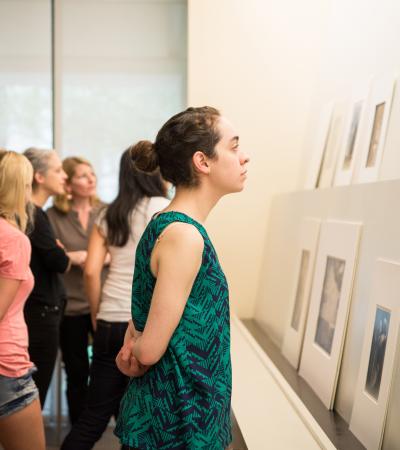 student looking at prints on display in museum