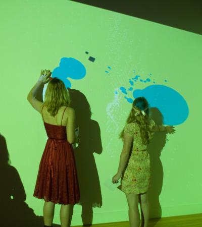 students interacting with projection on gallery wall