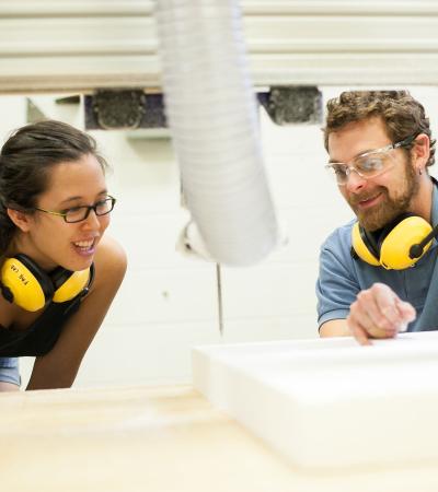 instructor demonstrating CNC router to student