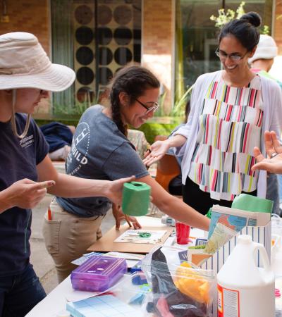 people surrounding a table containing craft supplies