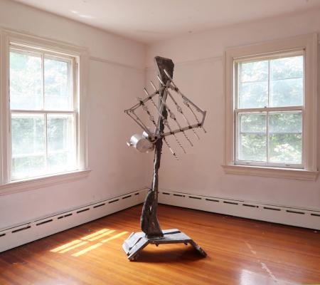 sculpture featured in middle of room with hardwood floors