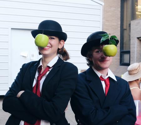 two people with apples hanging in front of their faces