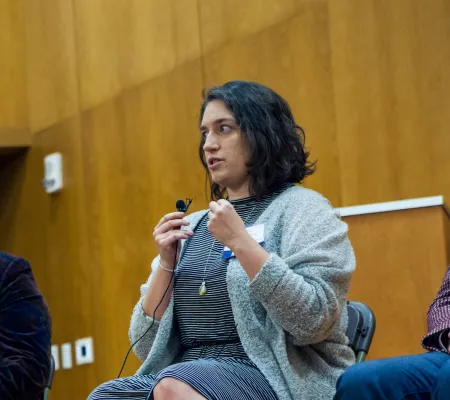 woman talking on panel and sitting in between two men