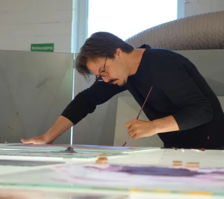 artist painting on glass tiles