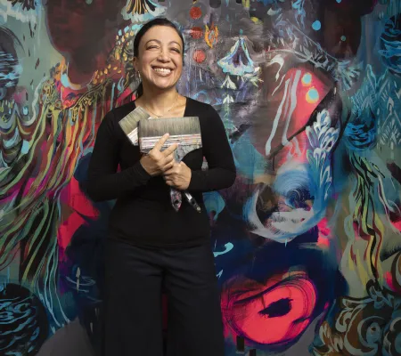 University of Texas at Austin's Studio Professor Scherezade Garcia standing in front of her large scale painting for the Praxis Gallery exhibition.