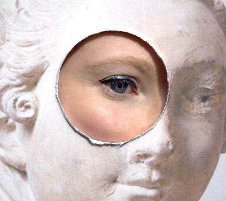 film still of an eye looking through a circular hole cut out of a board depicting marble sculpture on its face 