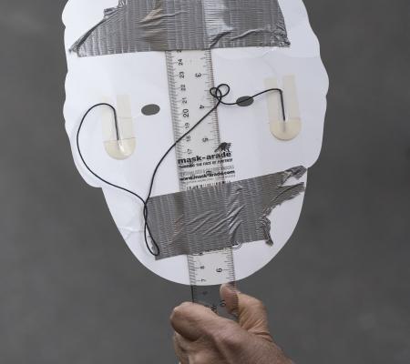 white outline of a head placed on a ruler with some wire