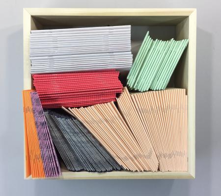 square shelving with zines of different colors inside
