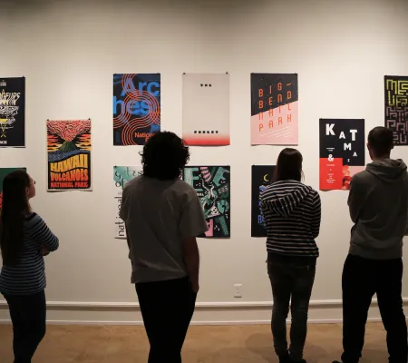 silhouettes of visitors in front of poster prints