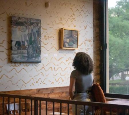 image of person looking at art on the wall in Medici coffee shop