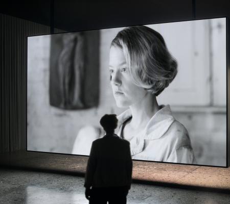 image of person in gallery looking at black and white photo of woman