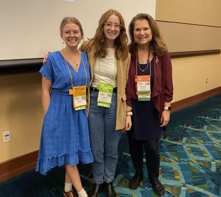 image of 3 people standing together at a conference