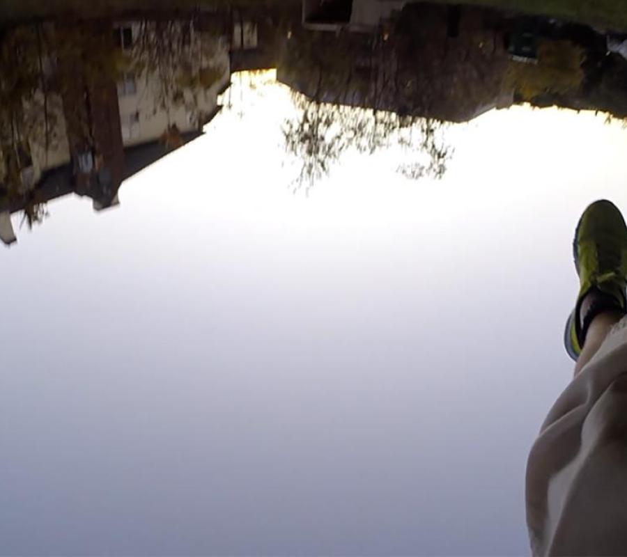 composite image of human legs and feet shown above reflection of water in landscape