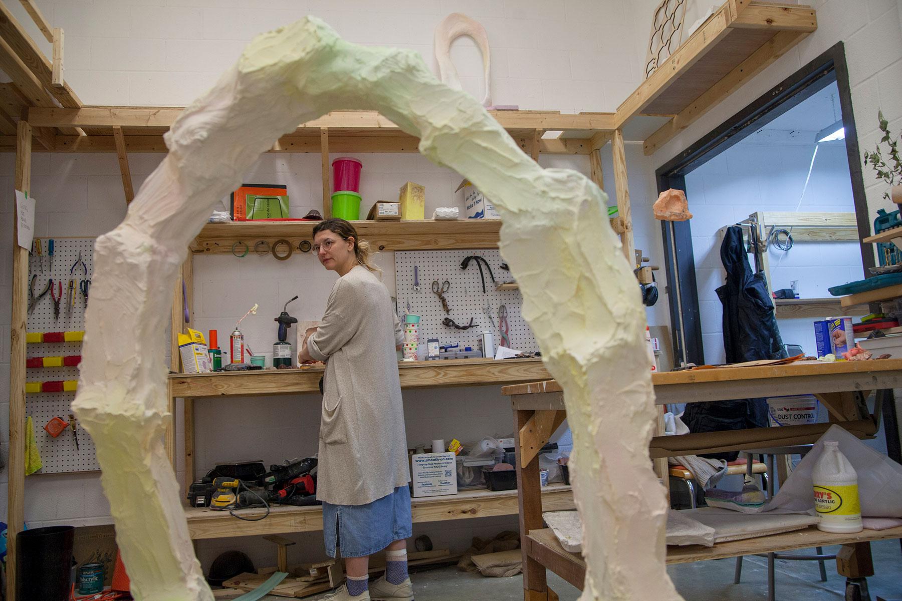 student in studio space with sculpture in foreground