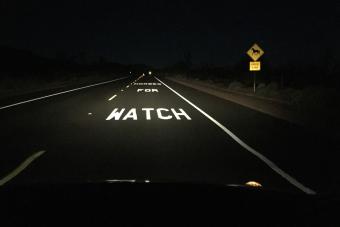 lanes of highway at night illuminated by car headlights