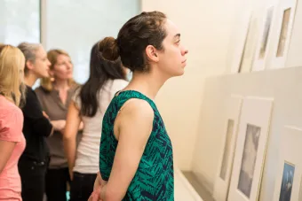 student looking at prints on display in museum