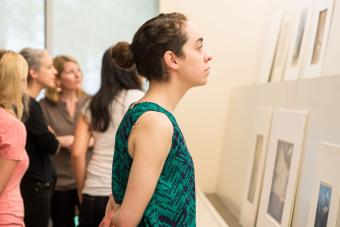 student looking at prints on display in museum