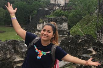 student wearing Longhorn shirt standing on pyramid in Guatemala