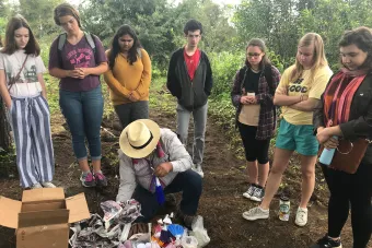 group of students observing man in hat