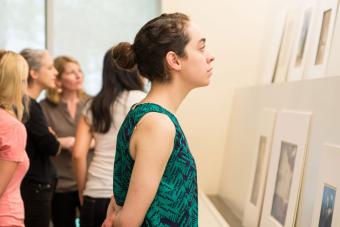 student looking at framed prints in museum