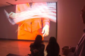 people watching video on screen in darkened space