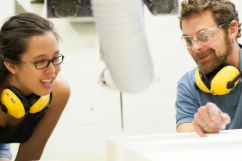 two people working on CNC machine