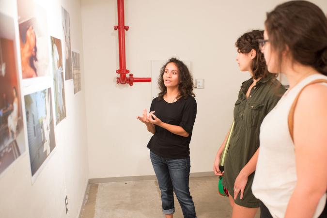 students in studio discussing photographs on wall