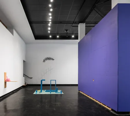 Installation with purple and white walls surrounding a freestanding object