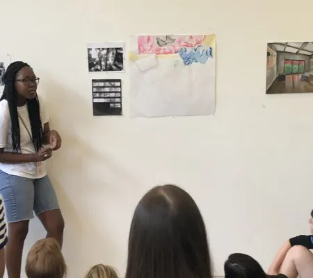 A group of Summer ST.ART Pre-College students at UT Austin gathered in a critique space 