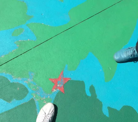 two shoes visible on colored concrete floor with red star