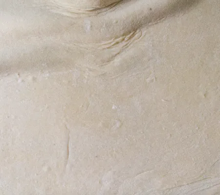 texture of beige dough with spots of flour 