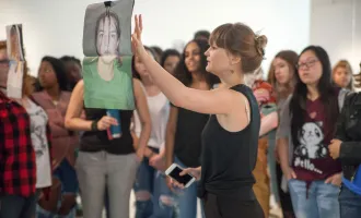 person discussing hanging work with crowd of people